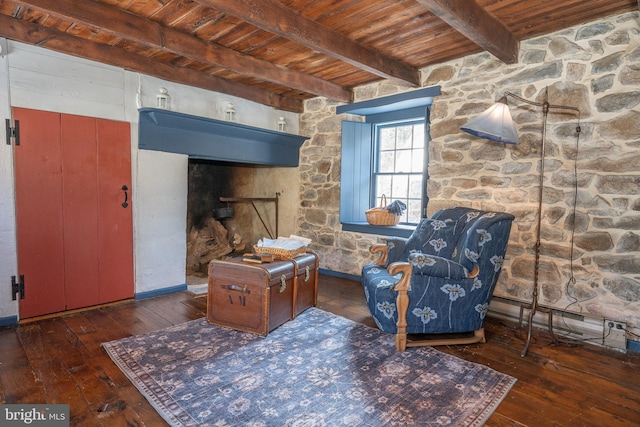 living area with beam ceiling, dark wood-type flooring, and wooden ceiling