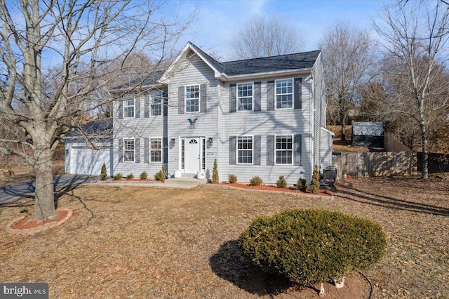 colonial home featuring a garage and central air condition unit