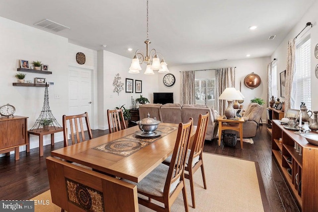 dining area with dark hardwood / wood-style floors and a notable chandelier