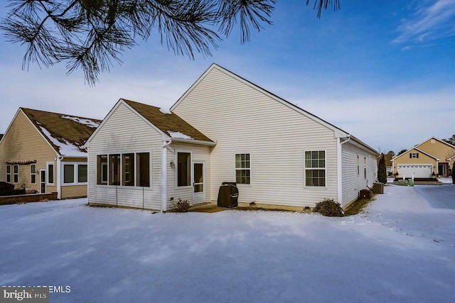 view of snow covered back of property