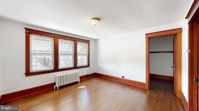 interior space with dark hardwood / wood-style flooring and radiator heating unit