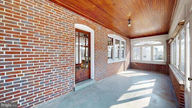 unfurnished sunroom with wooden ceiling