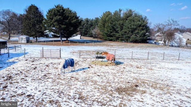 yard covered in snow with a rural view