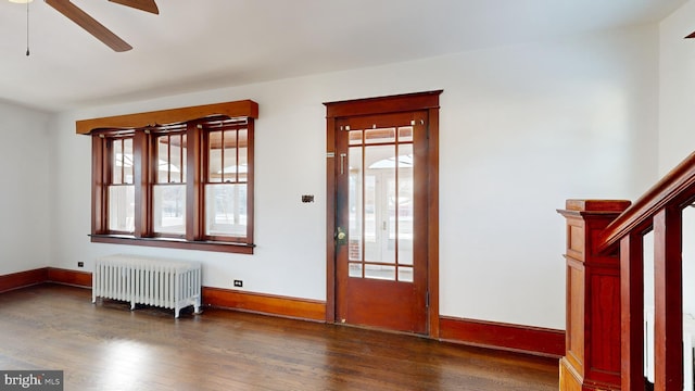 entrance foyer with dark hardwood / wood-style flooring, ceiling fan, radiator heating unit, and a healthy amount of sunlight