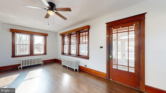 entryway featuring dark wood-type flooring, ceiling fan, and radiator heating unit