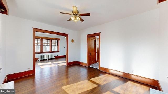 empty room featuring radiator, dark hardwood / wood-style floors, and ceiling fan