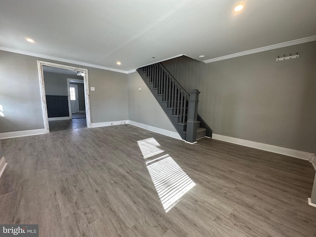 spare room featuring wood-type flooring and crown molding