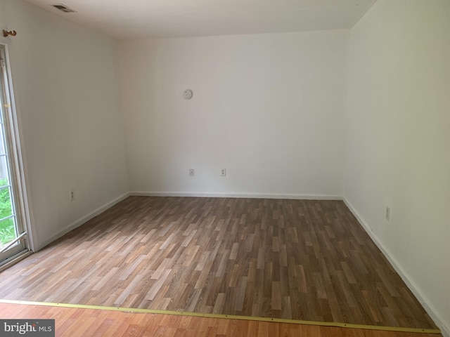 empty room with dark hardwood / wood-style flooring