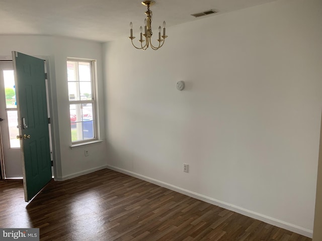 foyer featuring a notable chandelier, a wealth of natural light, and dark wood-type flooring