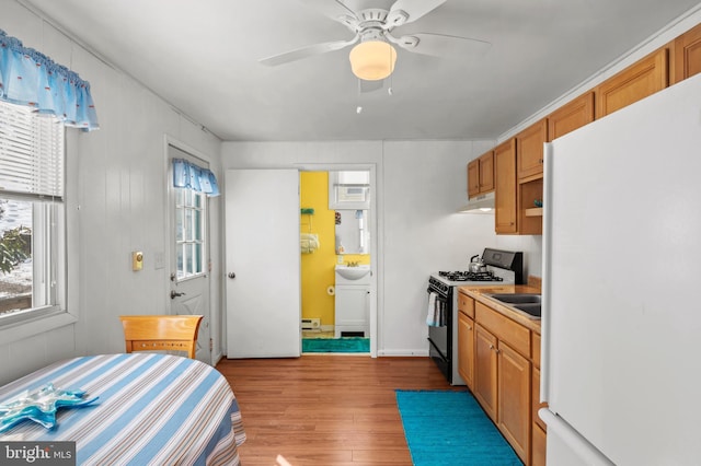 kitchen with gas stove, a healthy amount of sunlight, and white refrigerator