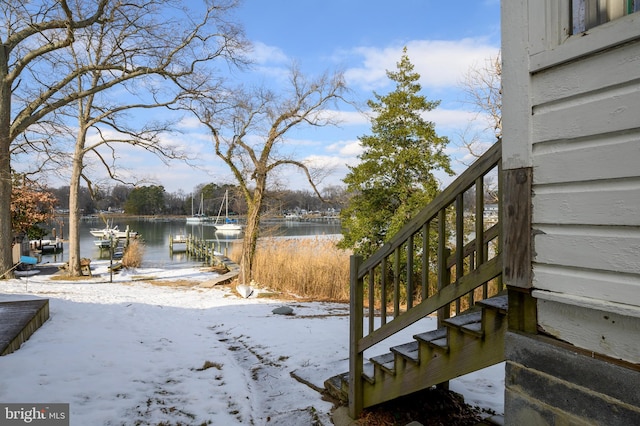 snowy yard featuring a water view