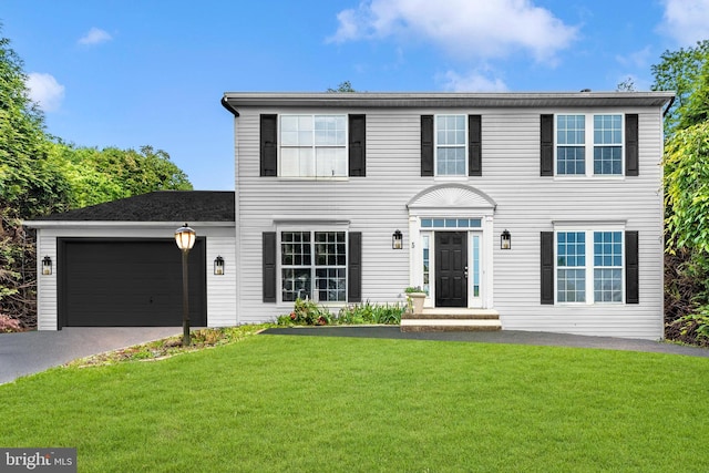 colonial house with a garage and a front yard