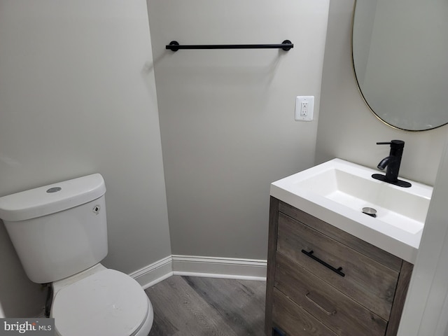 bathroom with hardwood / wood-style flooring, vanity, and toilet