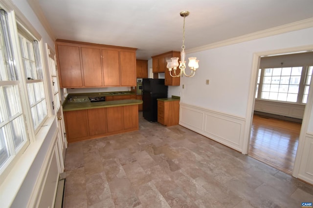 kitchen with crown molding, a chandelier, black fridge, and pendant lighting