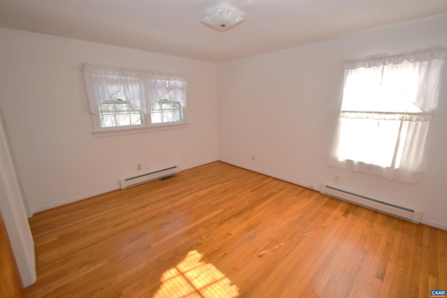 empty room with a baseboard radiator and light wood-type flooring