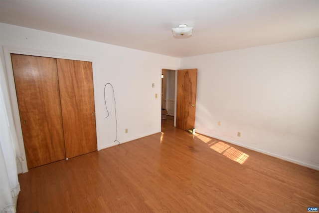 unfurnished bedroom featuring a closet and wood-type flooring