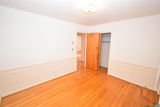 unfurnished bedroom with a closet and light hardwood / wood-style floors