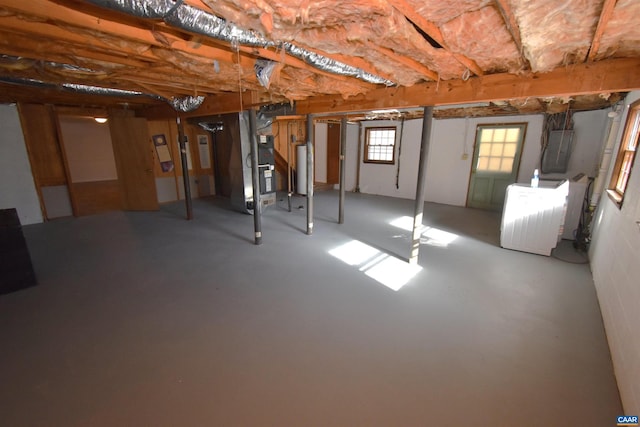 basement featuring electric panel, heating unit, and washer / clothes dryer