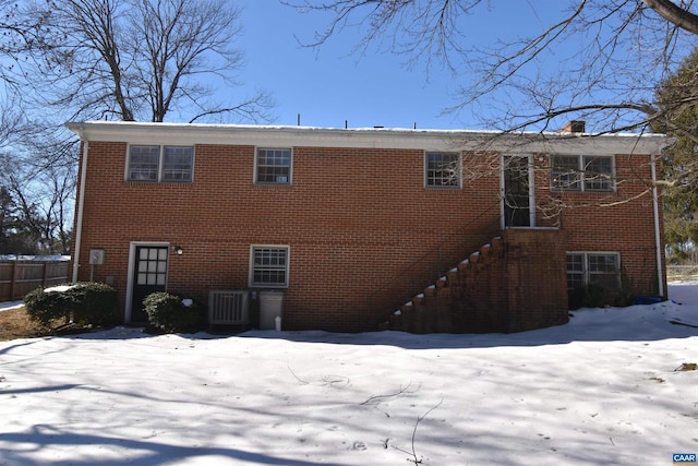 snow covered rear of property with central AC