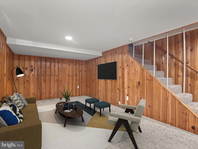 unfurnished living room featuring beam ceiling, carpet floors, and wood walls