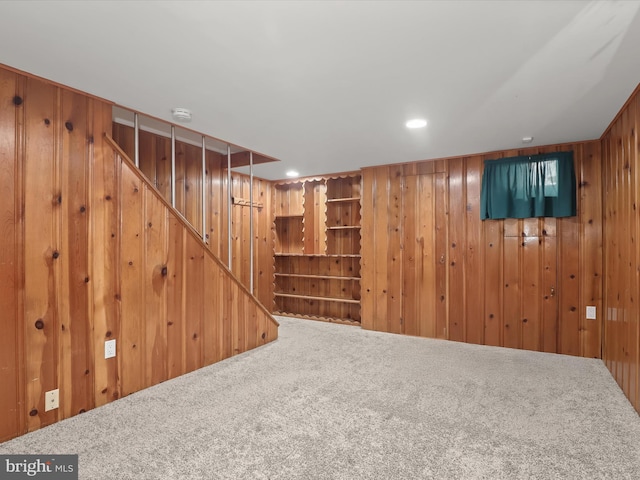 basement featuring carpet floors and wooden walls