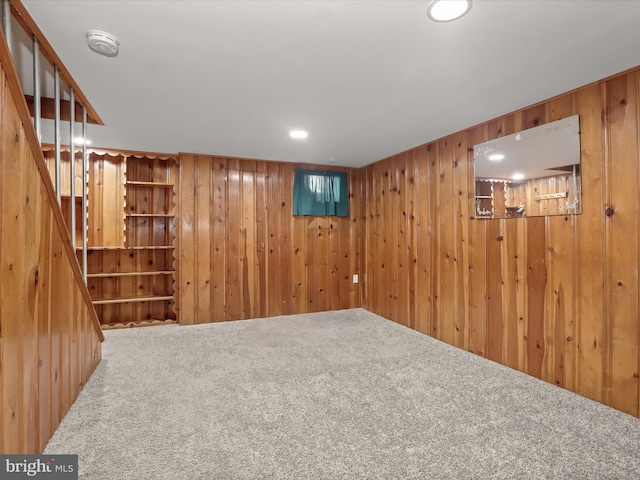 basement featuring wood walls and carpet flooring