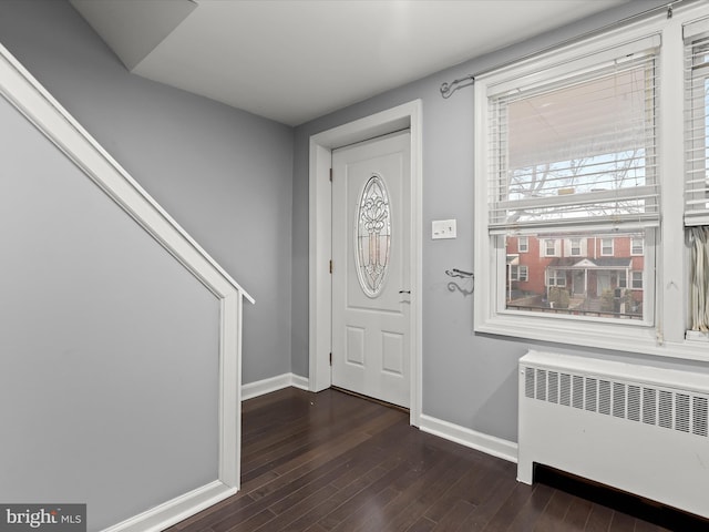 foyer with radiator, dark wood-type flooring, and a healthy amount of sunlight