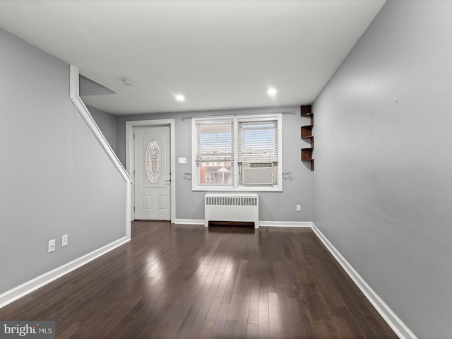 unfurnished living room with radiator heating unit and dark hardwood / wood-style floors