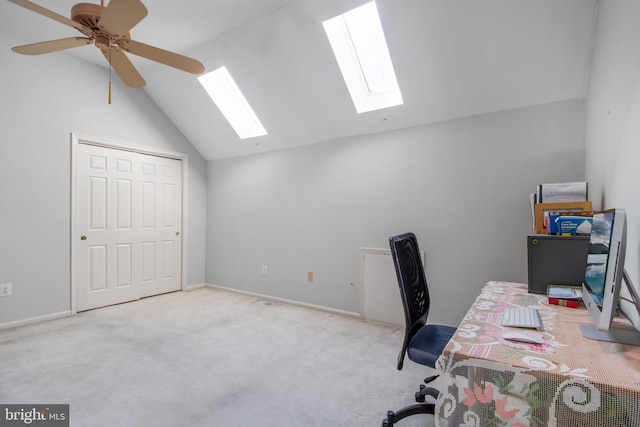 carpeted office featuring ceiling fan and vaulted ceiling with skylight