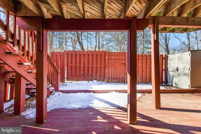 snow covered deck featuring a shed