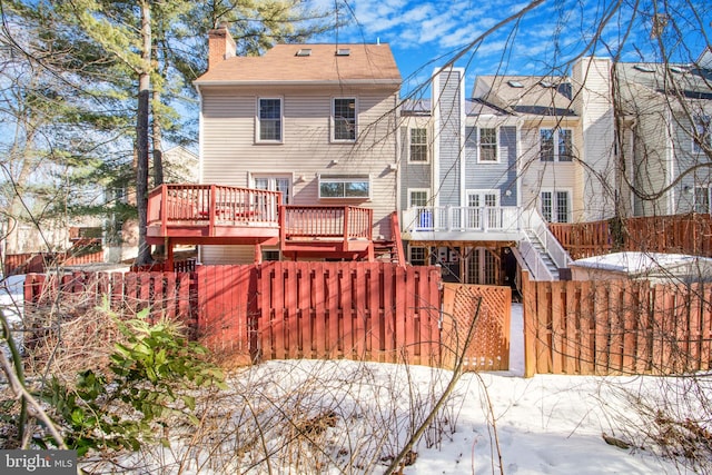 snow covered house featuring a wooden deck