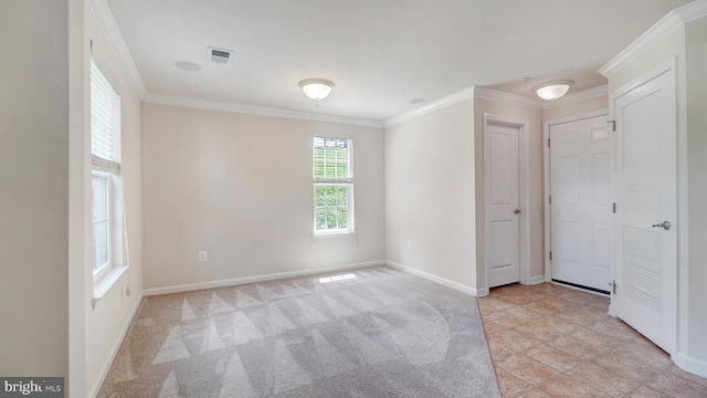 spare room with crown molding and light colored carpet