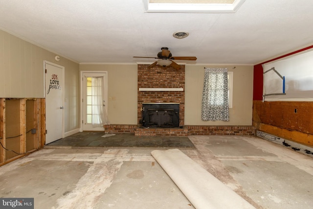 unfurnished living room featuring ceiling fan, ornamental molding, and a brick fireplace