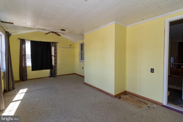 carpeted spare room featuring crown molding and lofted ceiling