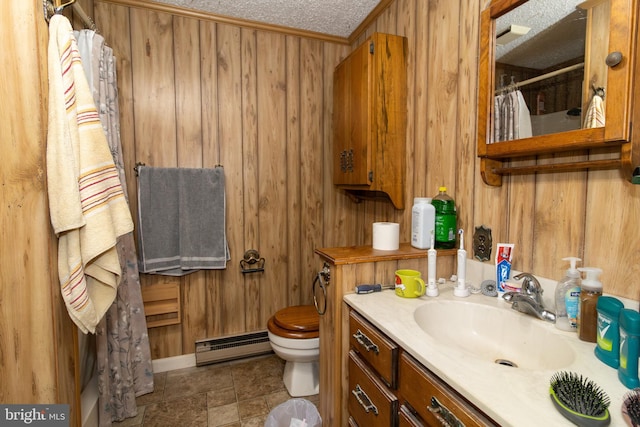 bathroom featuring a baseboard heating unit, wooden walls, vanity, a textured ceiling, and toilet