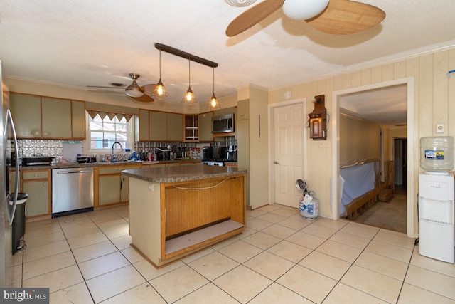 kitchen with a breakfast bar, pendant lighting, ceiling fan, stainless steel appliances, and crown molding