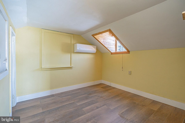 additional living space featuring lofted ceiling with skylight, dark wood-type flooring, and a wall mounted AC