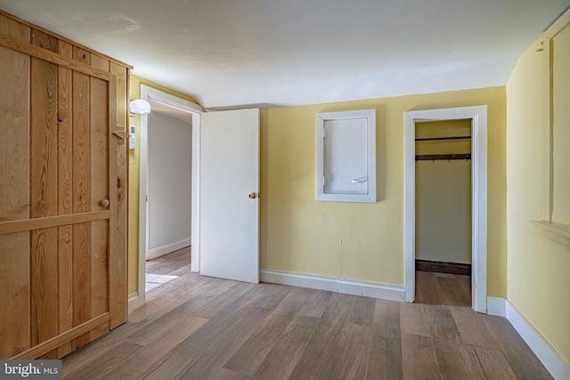 unfurnished bedroom featuring a walk in closet and wood-type flooring