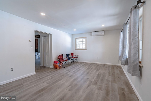 unfurnished room featuring light hardwood / wood-style floors and an AC wall unit