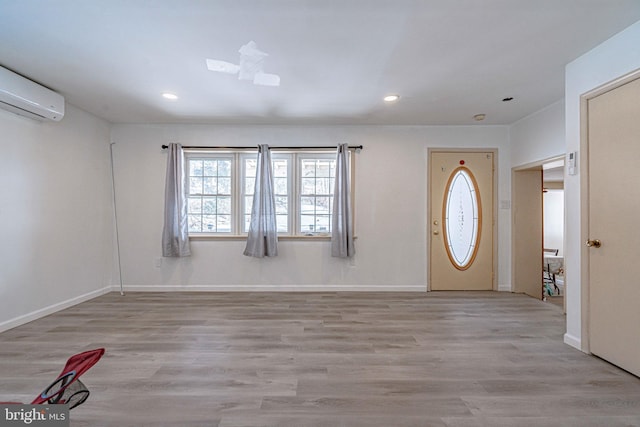 foyer entrance with an AC wall unit and light wood-type flooring