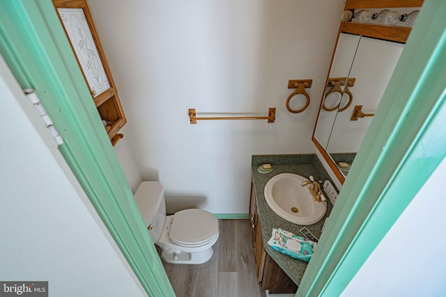 bathroom featuring wood-type flooring, vanity, and toilet