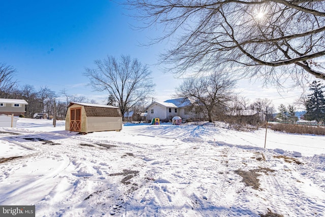 yard layered in snow with a shed