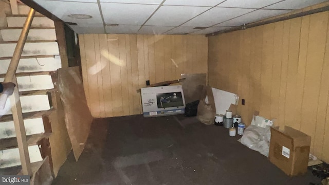 basement with heating unit and wood walls