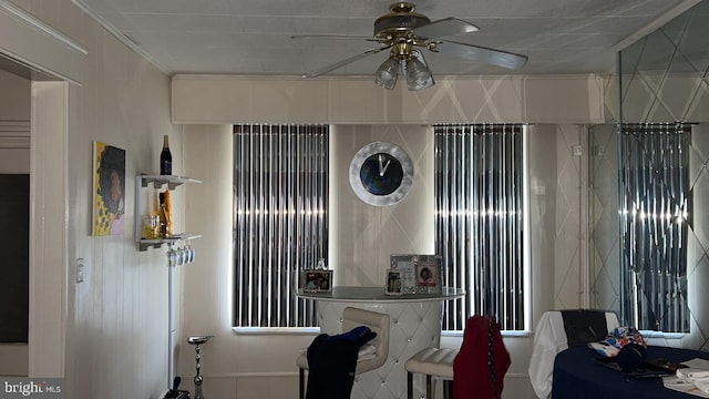 interior space featuring ornamental molding and ceiling fan