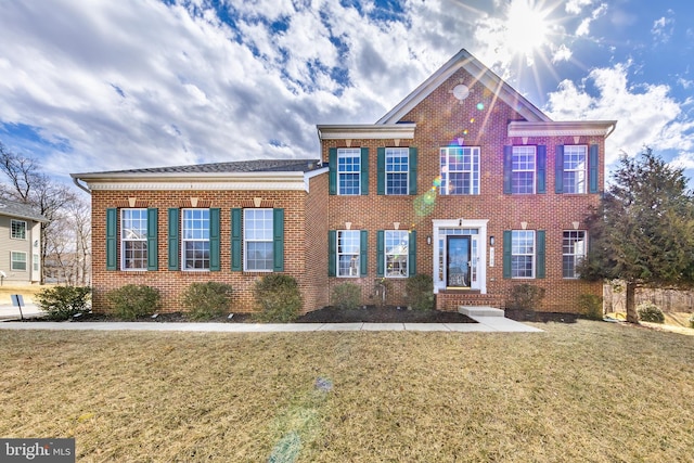 view of front of house with a front yard and brick siding