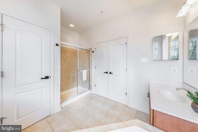 full bath featuring baseboards, a shower stall, vanity, and tile patterned floors
