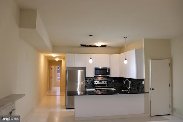 kitchen featuring hanging light fixtures, sink, tasteful backsplash, white cabinetry, and stainless steel appliances