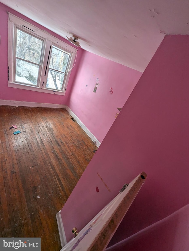 additional living space with dark wood-type flooring