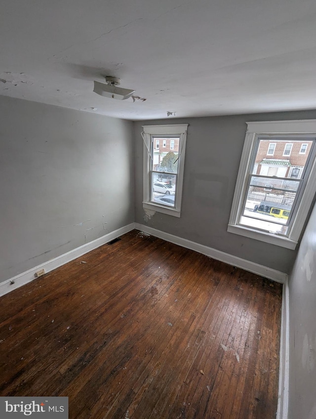 unfurnished room with dark hardwood / wood-style flooring