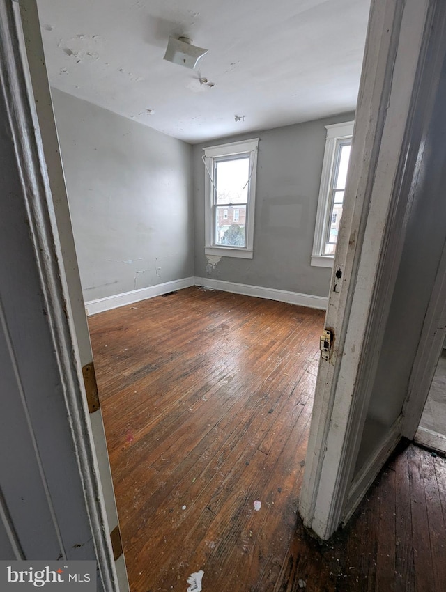 unfurnished room with dark hardwood / wood-style flooring